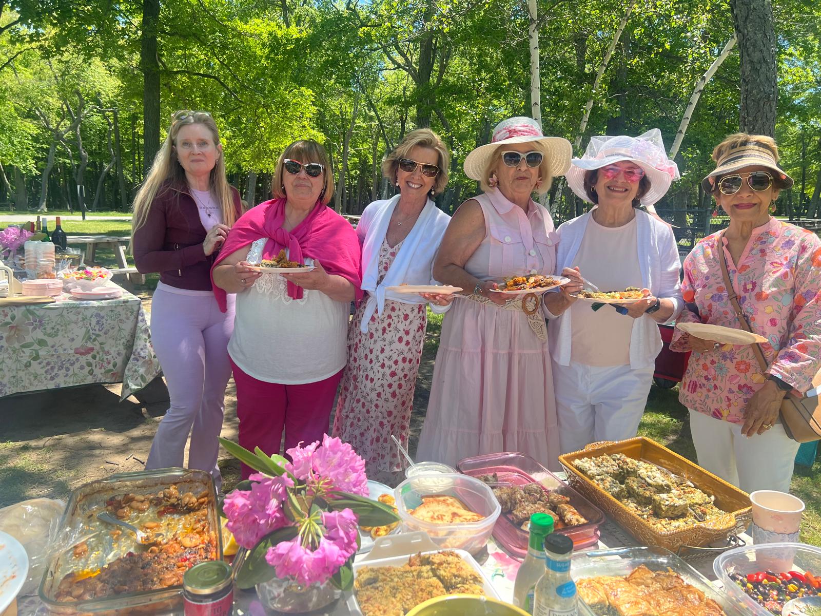 Neighbors sharing a potluck meal together outdoors at a RIHWC community supper